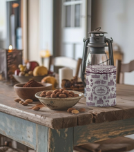 Load image into Gallery viewer, A decorative tin of La Maison du Chocolat chocolate on a rustic wooden table, surrounded by bowls of almonds and cocoa powder, with a vintage lantern in the background.