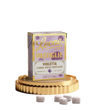 Load image into Gallery viewer, Box of Leone Pastiglie Violetta on a decorative stand with pastilles on a neutral background