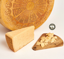 Load image into Gallery viewer, Valserena 24 mos brown cow Parmigiano Reggiano cheese wheel and wedge with a wooden board on a white background