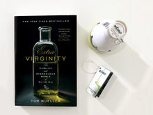 Load image into Gallery viewer, Book cover of Tom Mueller's Extra Virginity:  The Sublime and Scandalous World of Olive Oil, Along a Bottle and Label of De Carlo Olive Oil