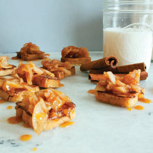 Load image into Gallery viewer, Divina French Mini Toasts with apple pie filling on top, along side a glass of milk in a mason jar and raw cinnamon sticks - on white marble.