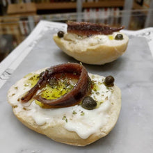 Load image into Gallery viewer, Salted capers on roasted roll, with white creamy cheese, olive oil and an anchovy fillet.