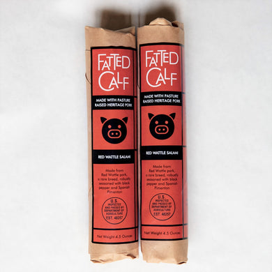 Two kraft wrapped, with red and black label, Fatted Calf artisan Red Wattle salami (Napa, California).