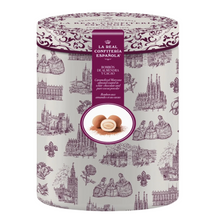 Load image into Gallery viewer, A cylindrical tin of La Real Conitería Española Bombon de Almenora Volcano chocolates, featuring a light gray patterned tin with purple illustrations of historic Madrid landmarks and a central purple label.
