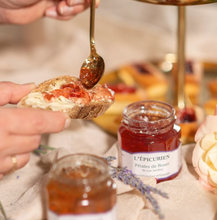 Load image into Gallery viewer, Person spreading jam on bread with a jar of 'L'Epicurien' jam in the foreground.
