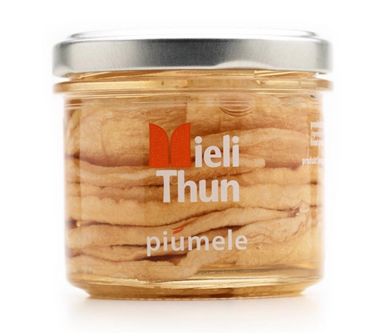 Clear jar filled with dried apple rings in clear acacia honey from Mieli Thun in Italy.