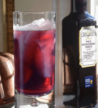 Load image into Gallery viewer, Bottle of Wine Forest Wild Huckleberry Shrub next to a glass filled with a red drink and ice.
