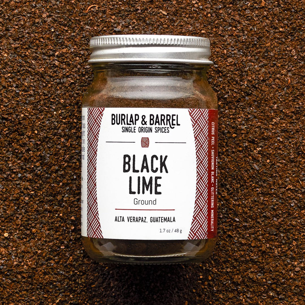 small glass jar with white label of Burlap & Barrel Black  Ground Lime Spice 