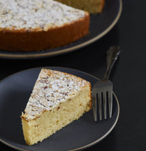 Load image into Gallery viewer, single layer, yellow almond gluten free cake, dusted with powdered sugar
