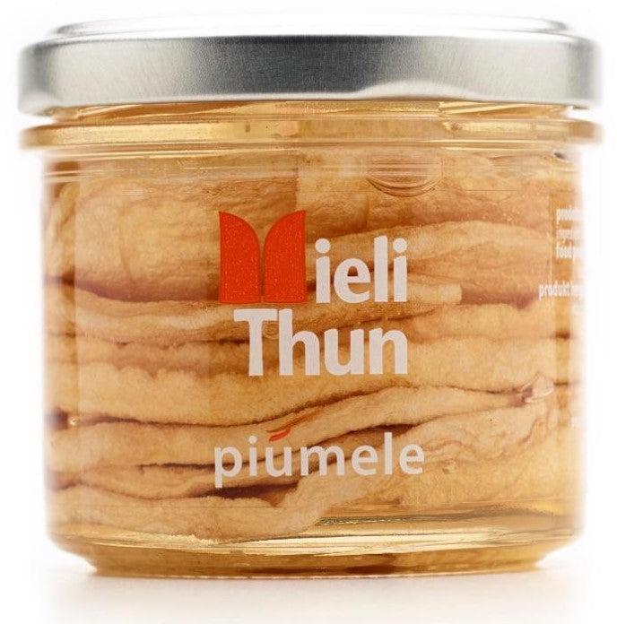 Clear jar filled with dried apple rings in clear acacia honey from Mieli Thun in Italy.