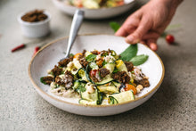 Load image into Gallery viewer, Beautiful and delicious looking pasta with long sliced green and yellow squash, and crunchy teff grain topping.
